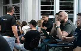 Alunos sorrindo ao lado do professor em ambiente educacional