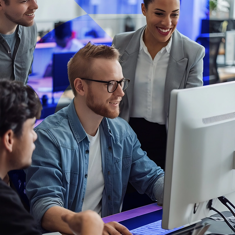 Colaboradores observando um funcionário usando um computador em escritório