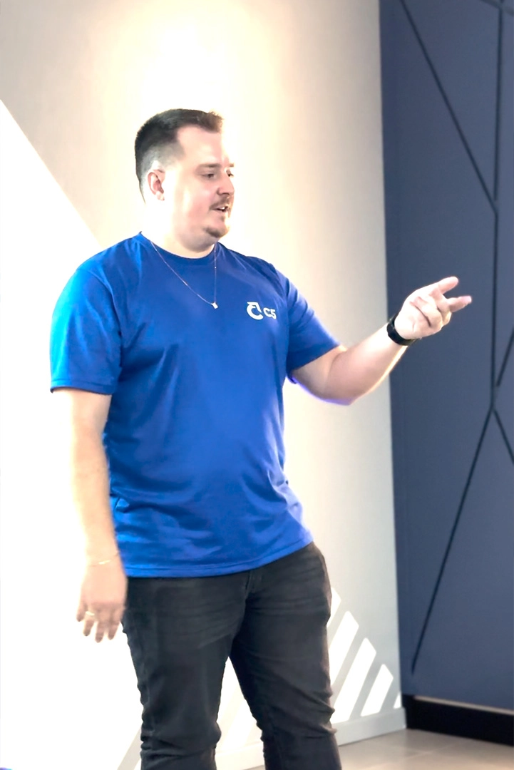 Especialista gesticulando na frente da sala usando camisa com a logo da C5 Educ